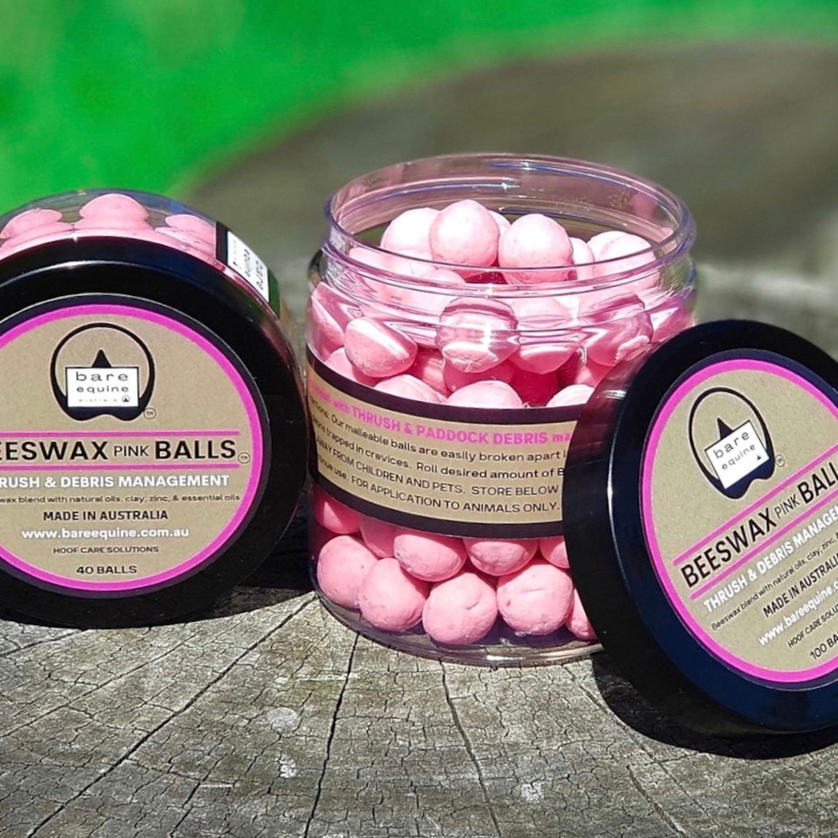 Pink beeswax balls in small container next to a large jar of pink beeswax balls.