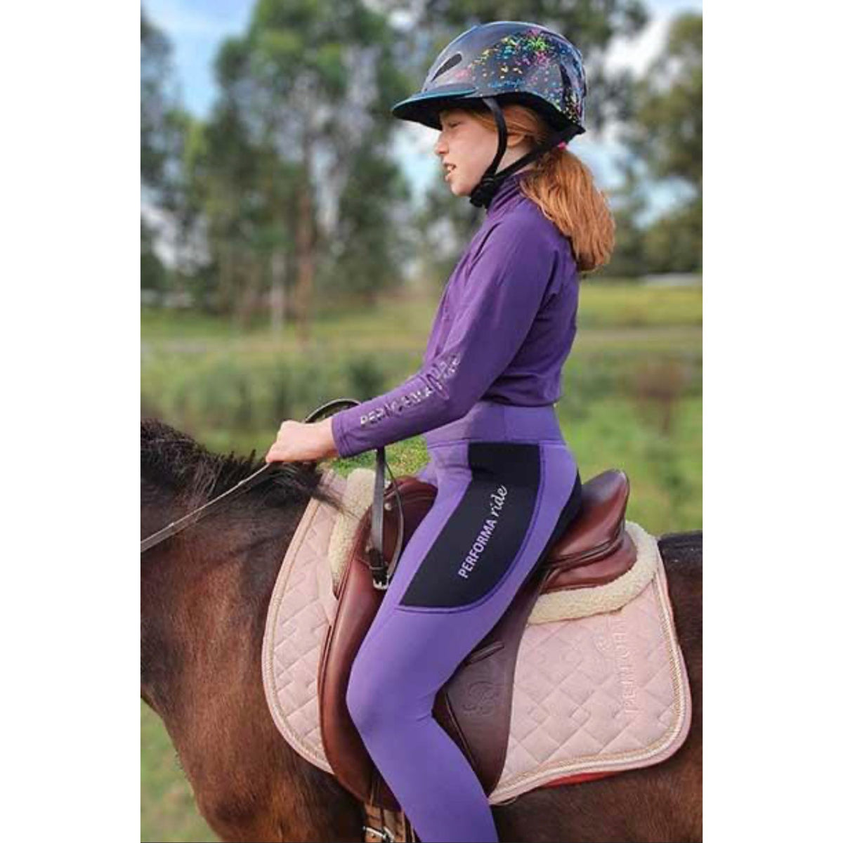 Girl riding horse wearing Purple youth winter riding top.