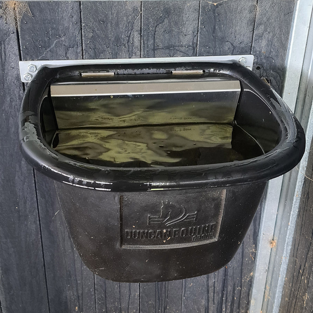 Black horse water tub mounted to wooden wall