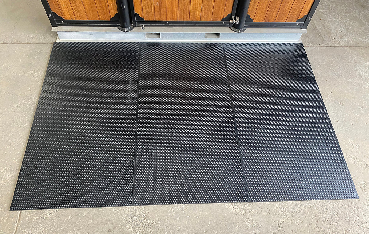 3 black rubber mats on stable floor