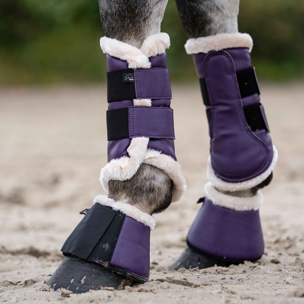 horse&#39;s legs with dark purple boots with white fluff