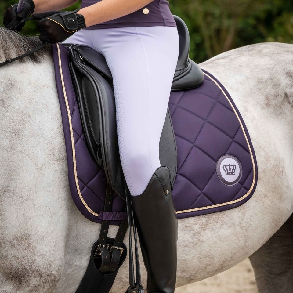 grey horse with purple saddle pad with gold trim and crown