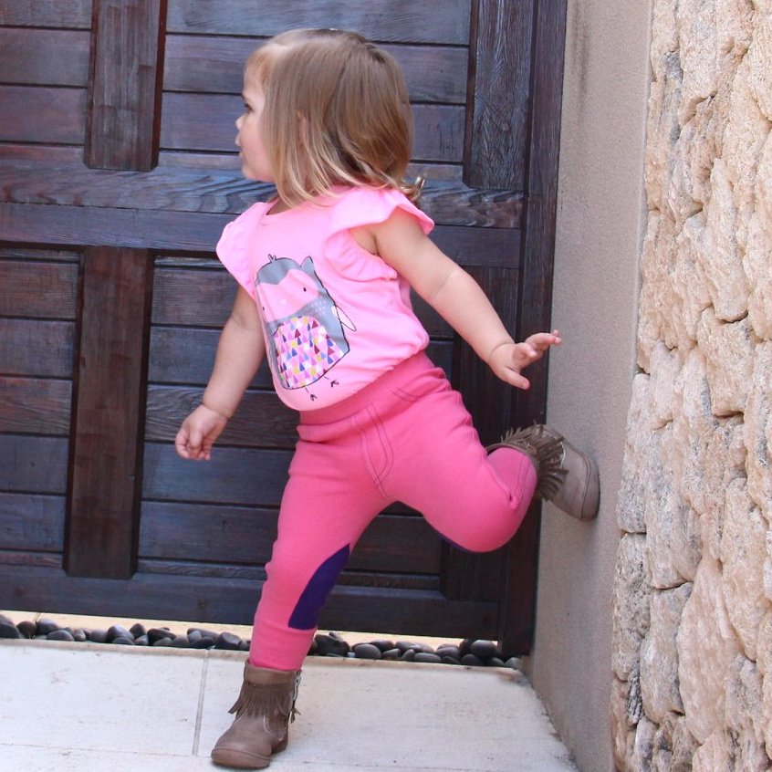 small girl dressed in pink top and pink jodhpurs