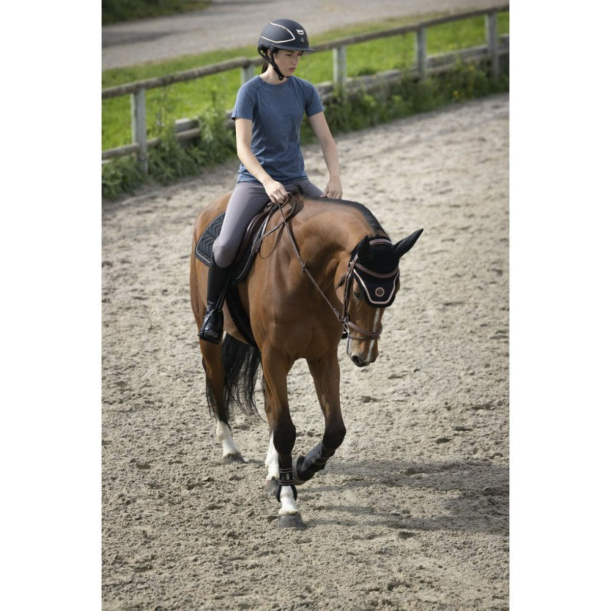 Girl riding bay horse whilst wearing the merino blend riding top