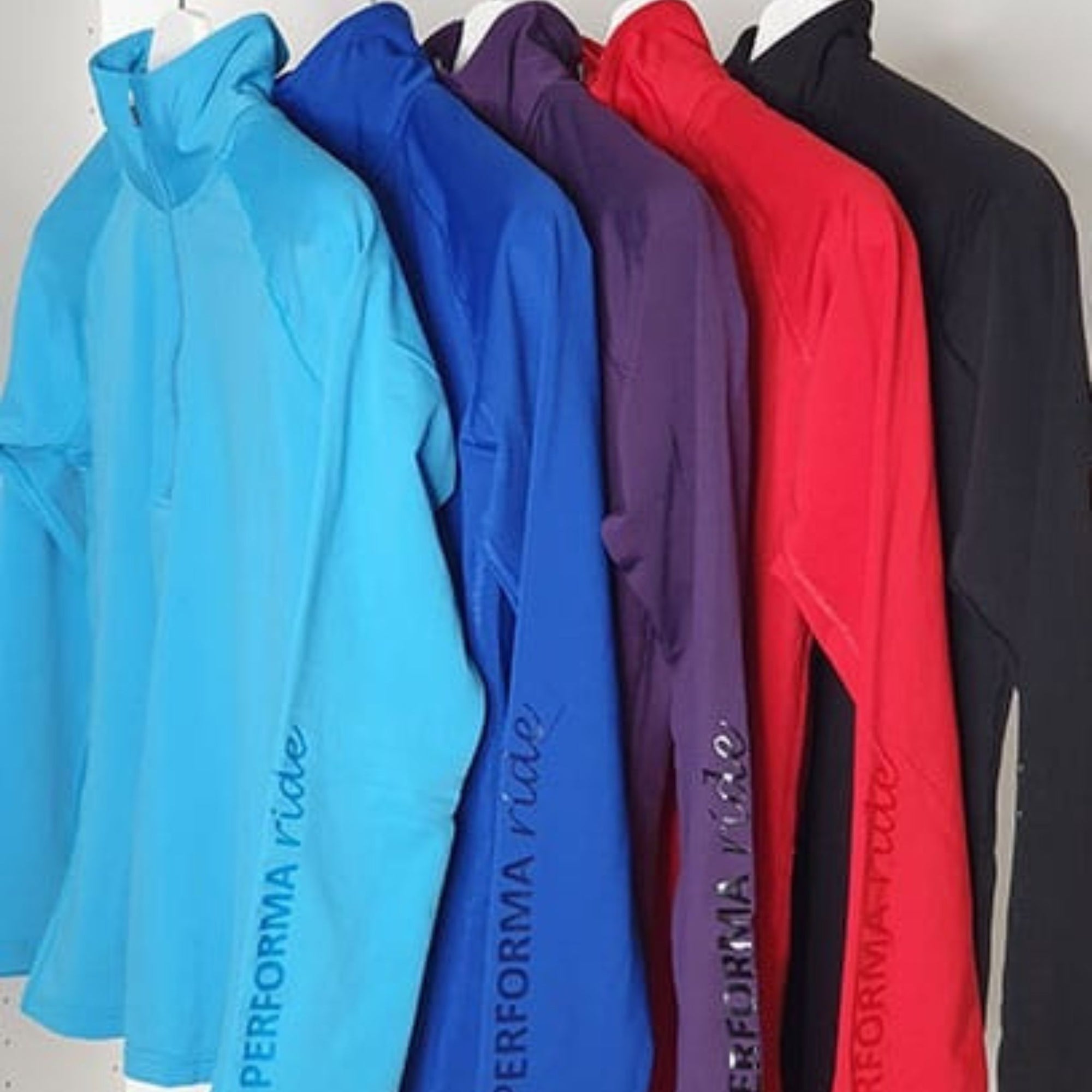 Light blue, royal blue, purple, red and black winter riding tops with performa ride logo on sleeve.