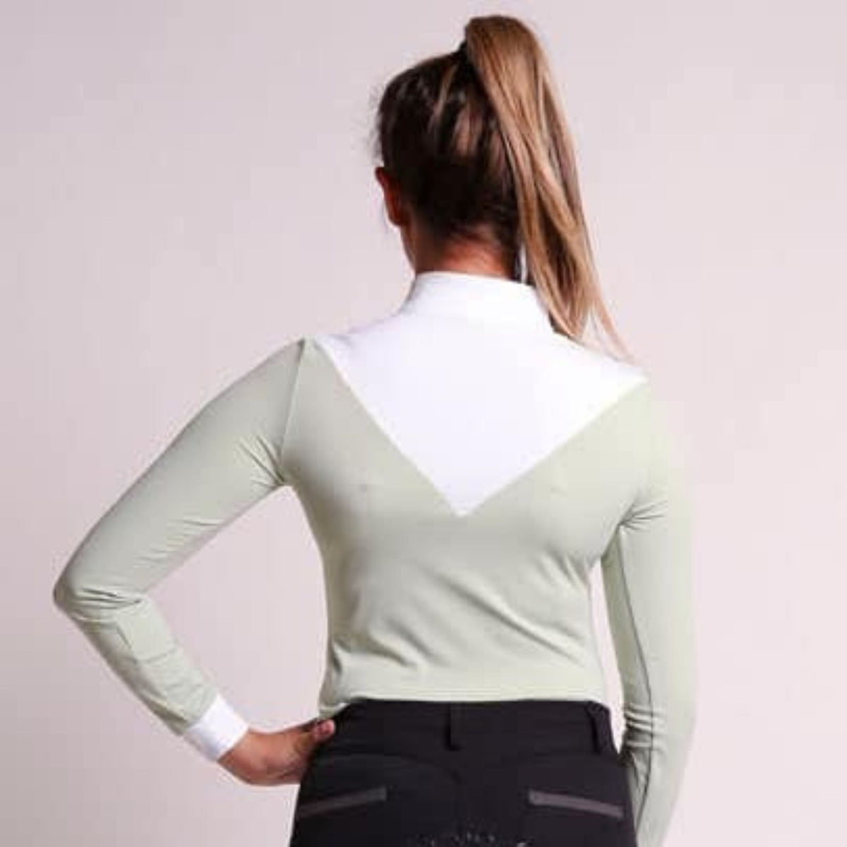 Back view of model wearing long sleeved green competition shirt.