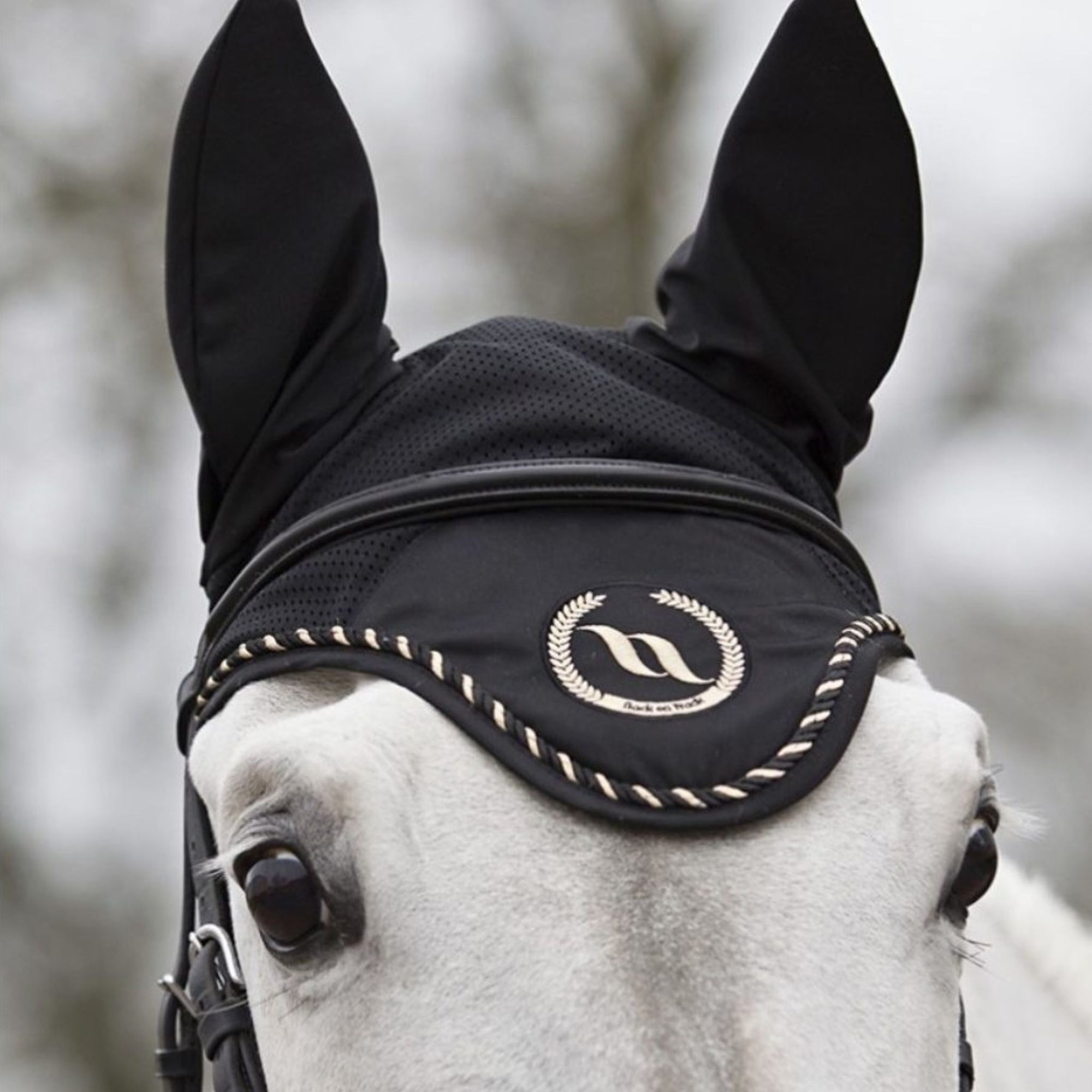 Black bonnet with a circular gold logo in the centre, and white and black rope lining the bonnet.