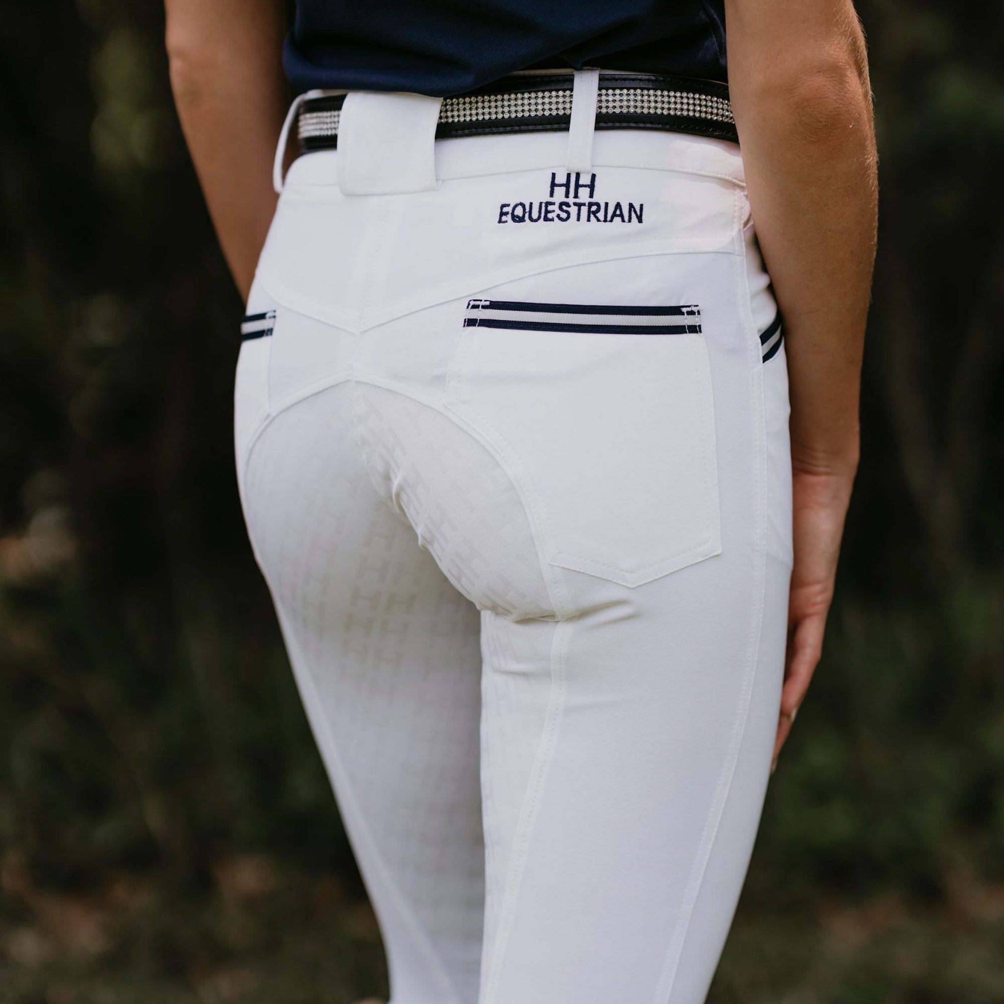 Lady wearing white breeches with navy stripes on front pockets.