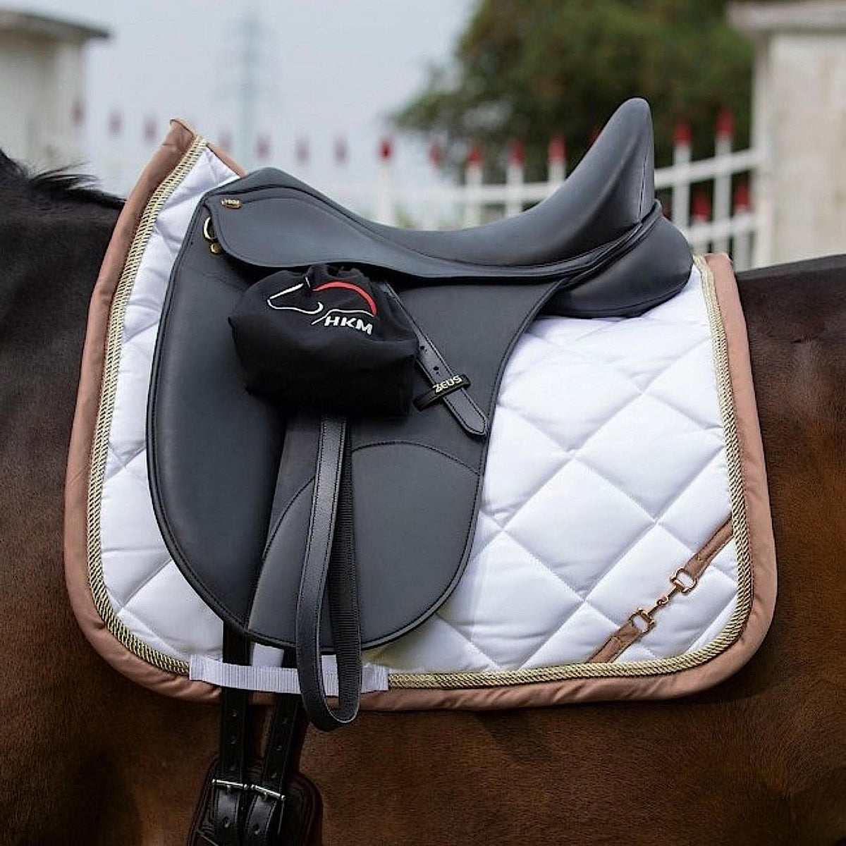 Stirrups rolled and covered with black covers with white horse head outline.