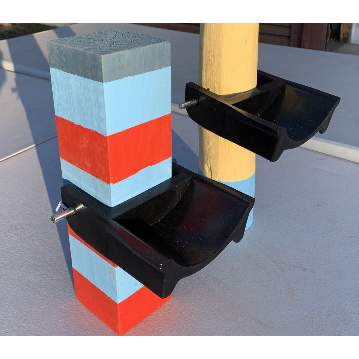 Black jump cups on two wooden posts, with pin going through posts.