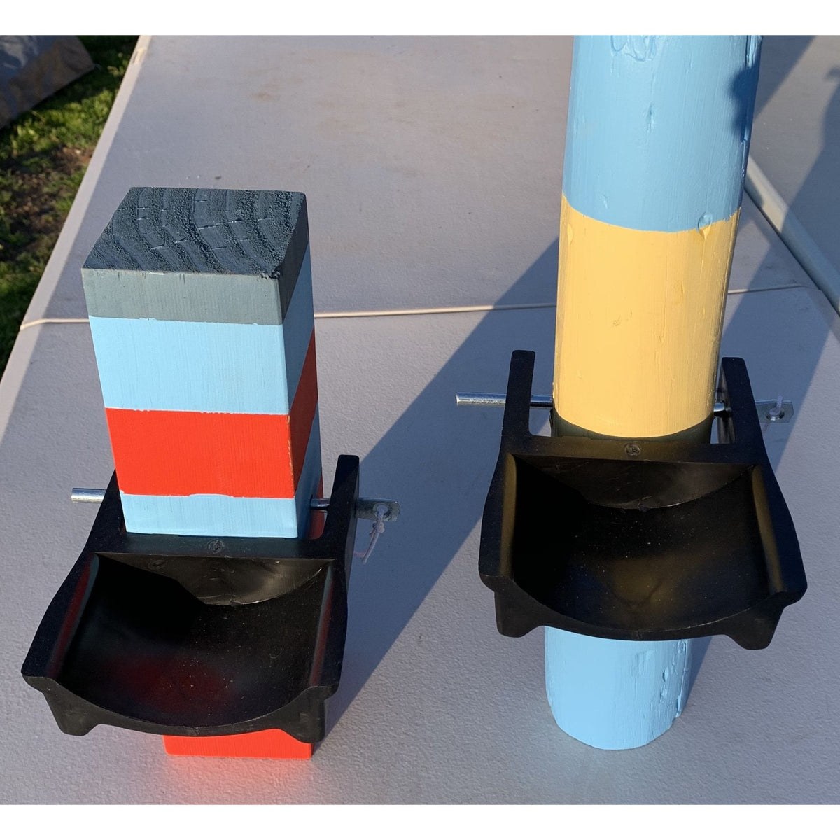 Front view of black jump cups inserted into two stripey posts.