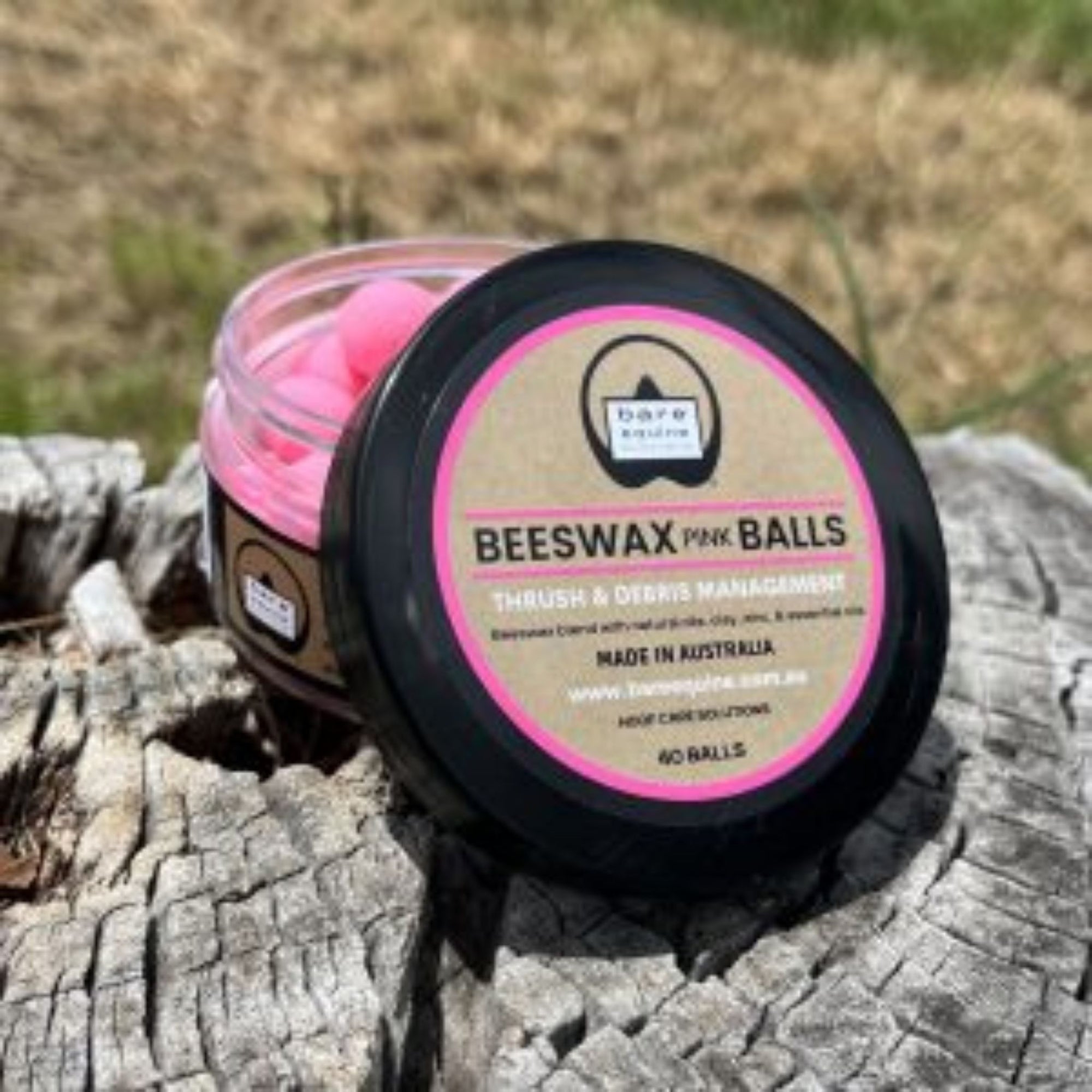 Pink beeswax balls in small container.