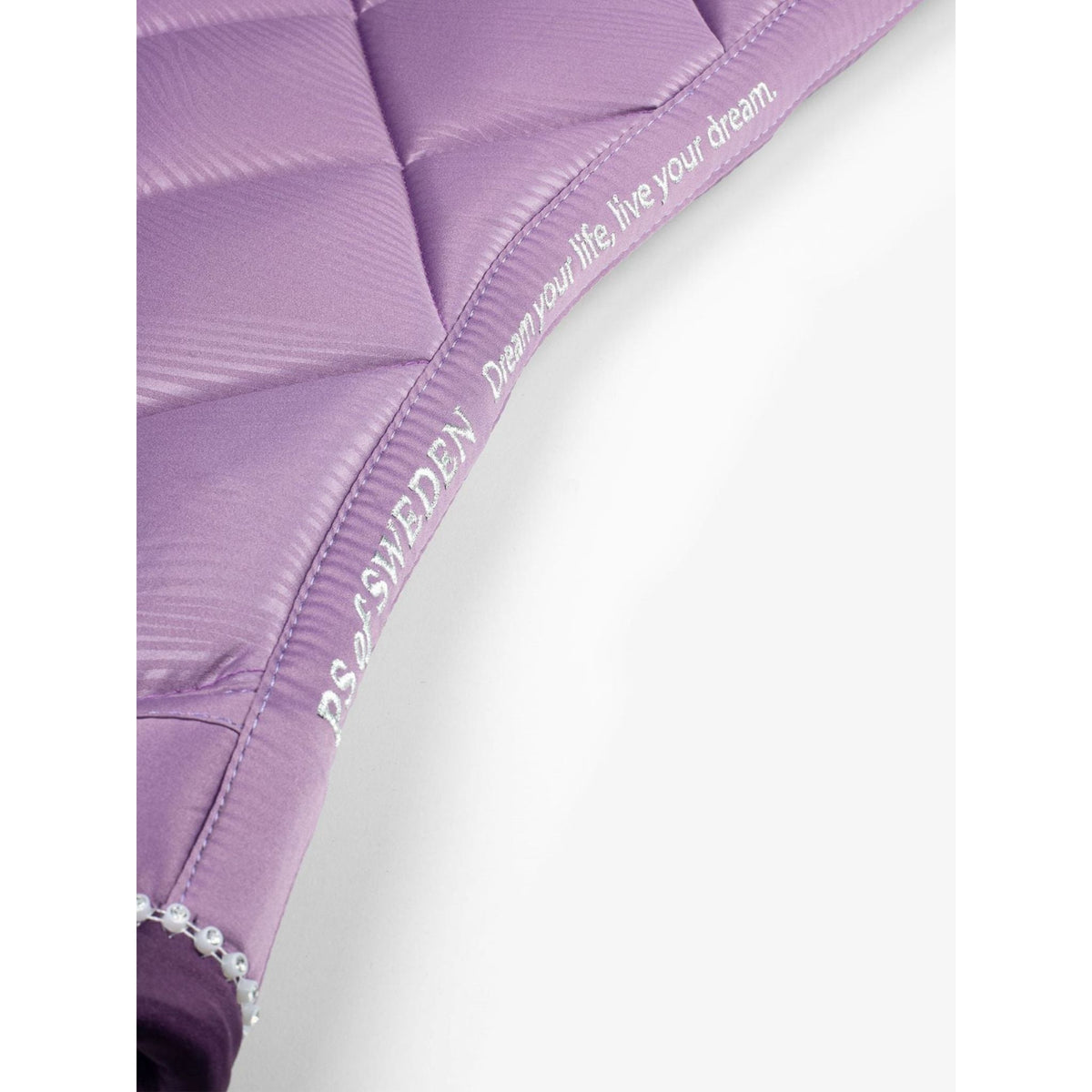 Close up of purple saddle pad with quote across top line.
