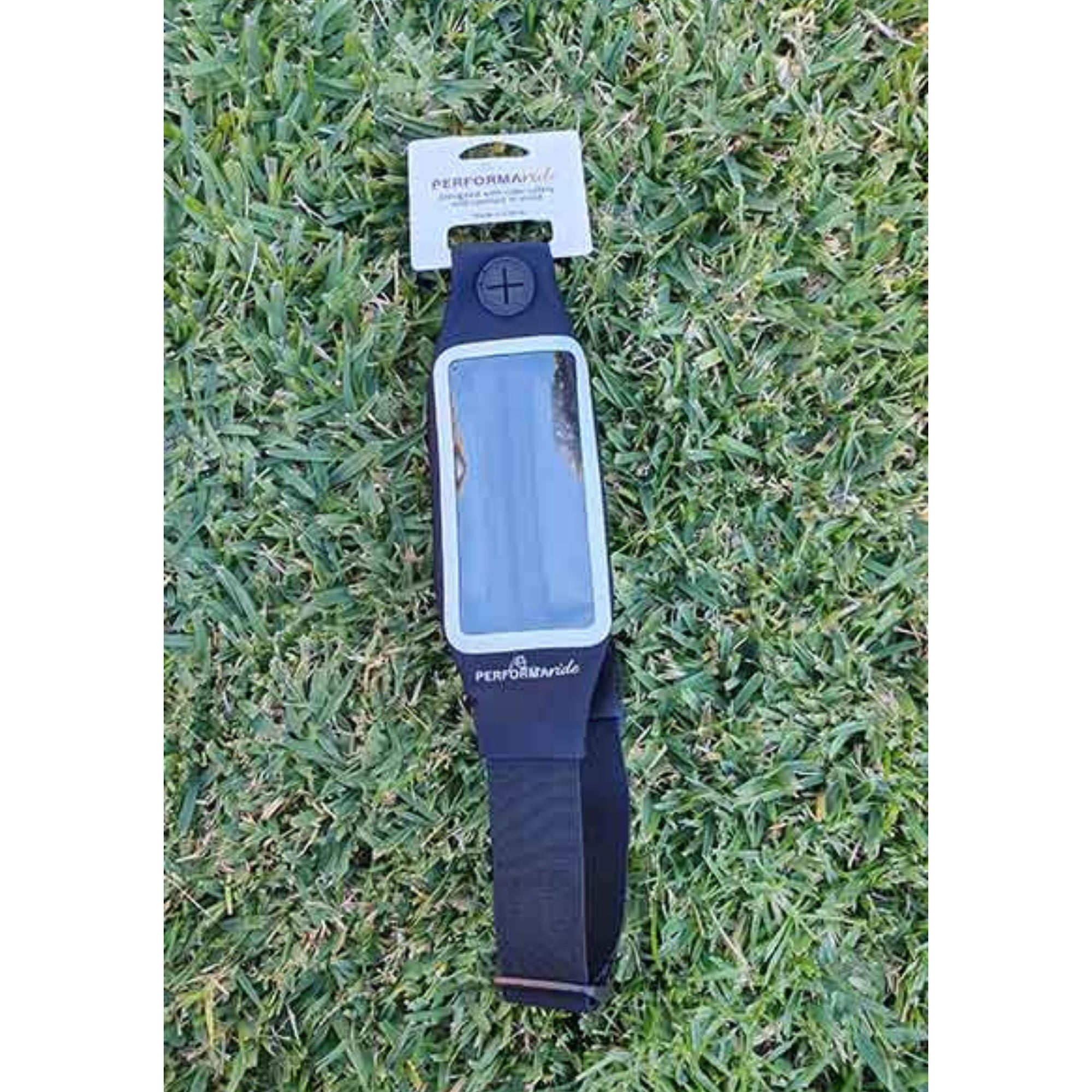Clear front phone belt with black band on grass surface.