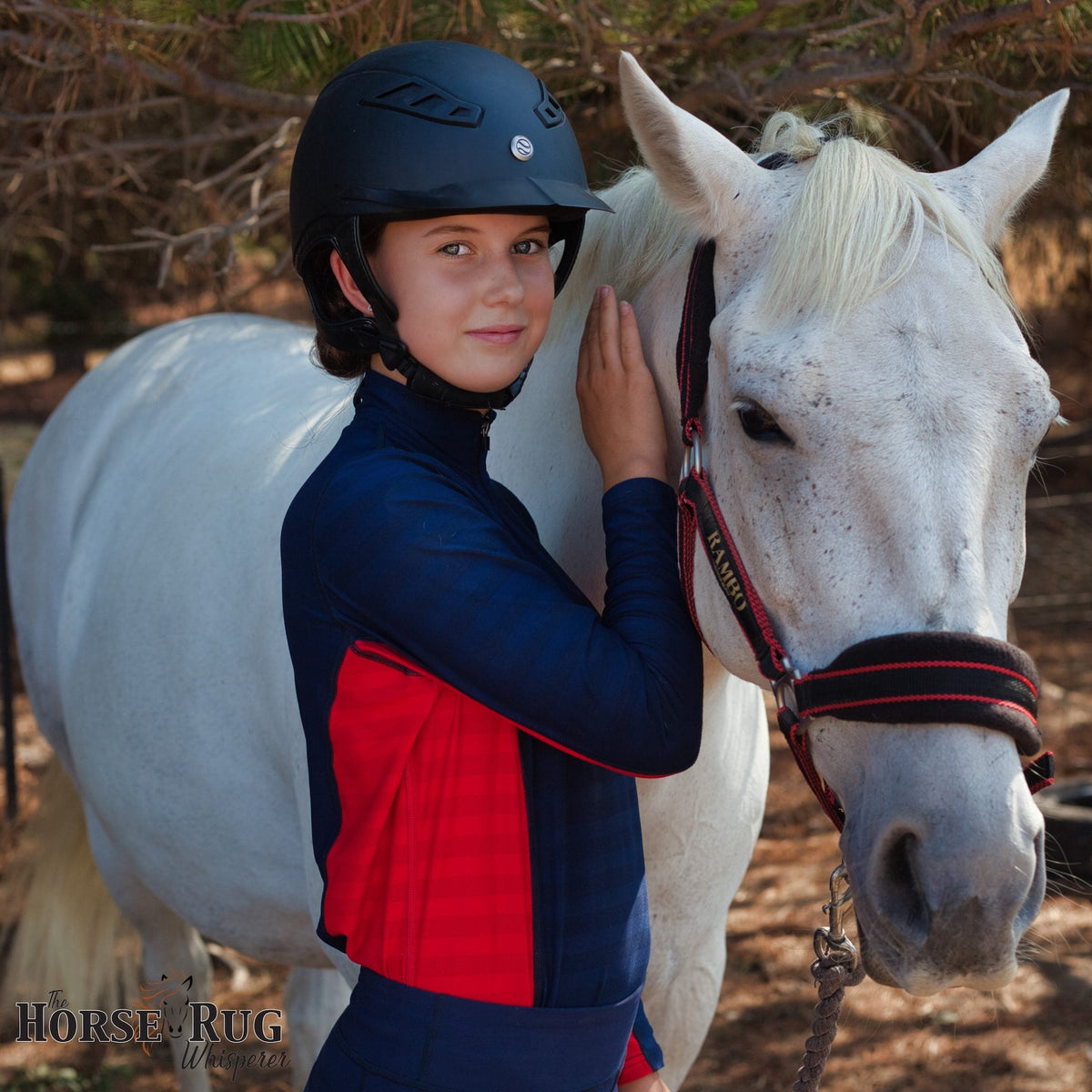 Lady holding grey horse, wearing navy long sleeve shirt with red side.