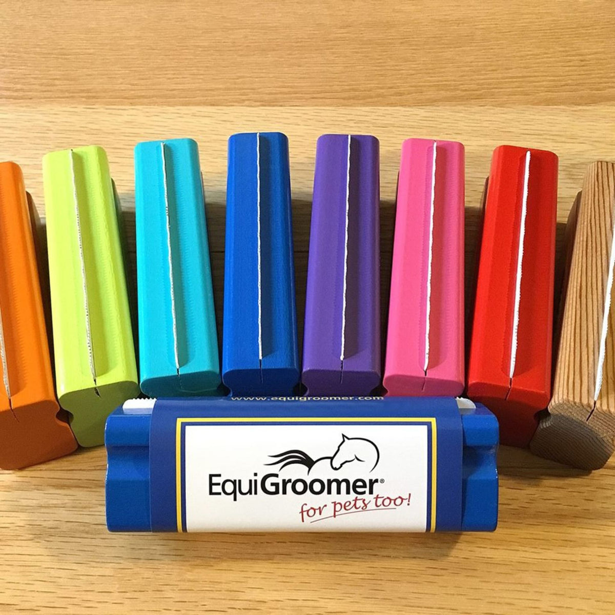 A row of varying coloured small equigroomers with their blades facing up.